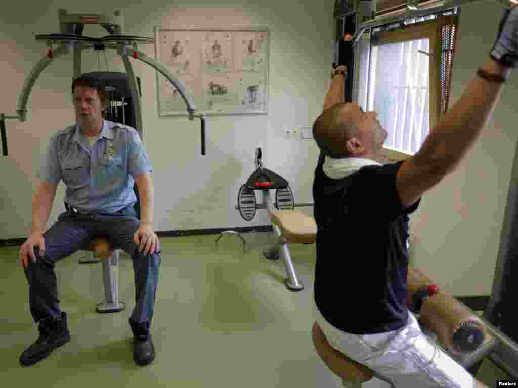 Security guards exercise at a gym shared with those accused of war crimes.