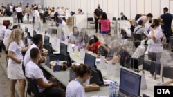 Election workers process ballots papers at an indoor sports and concert arena in Sofia on July 11. 