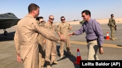 Defense Secretary Mark Esper (right) talks with U.S. troops in front of an F-22 fighter jet deployed to Prince Sultan Air Base in Saudi Arabia on October 22.