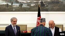 Presidential candidates Abdullah Abdullah (left) and Ashraf Ghani talk with outgoing President Hamid Karzai during a September 21 ceremony to form a unity government in Kabul.