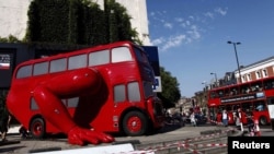 A London bus that has been transformed into a robotic sculpture by Czech artist David Cerny is assembled in front of the Czech Olympic headquarters in London.