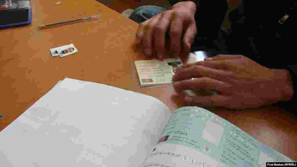 An employee at the registration office fills out information on a new voter card.