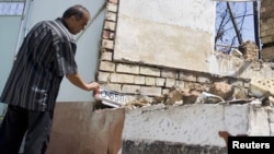 An ethnic Uzbek man in the yard of his house, burned out during the ethnic clashes in Osh in June.