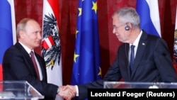 Austrian President Alexander Van der Bellen (right) and Russian President Vladimir Putin shake hands after a news conference in Vienna on June 5.