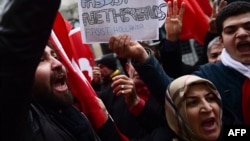 Protesters shout slogans and wave Turkish national flags in front of the Dutch Consulate in Istanbul on March 12.