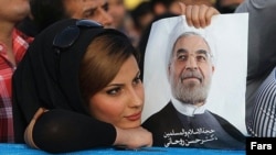 A supporter of Hassan Rohani holds a campaign poster of the candidate during a rally in Ahvaz in western Iran.