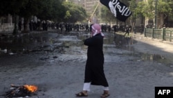 An Egyptian protester holds an Al-Qaeda affiliated flag near the U.S. Embassy in Cairo on September 14.