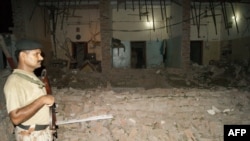 A Pakistani paramilitary soldier stands at the site of suicide car bombing in the southern city of Sukkur on July 24.