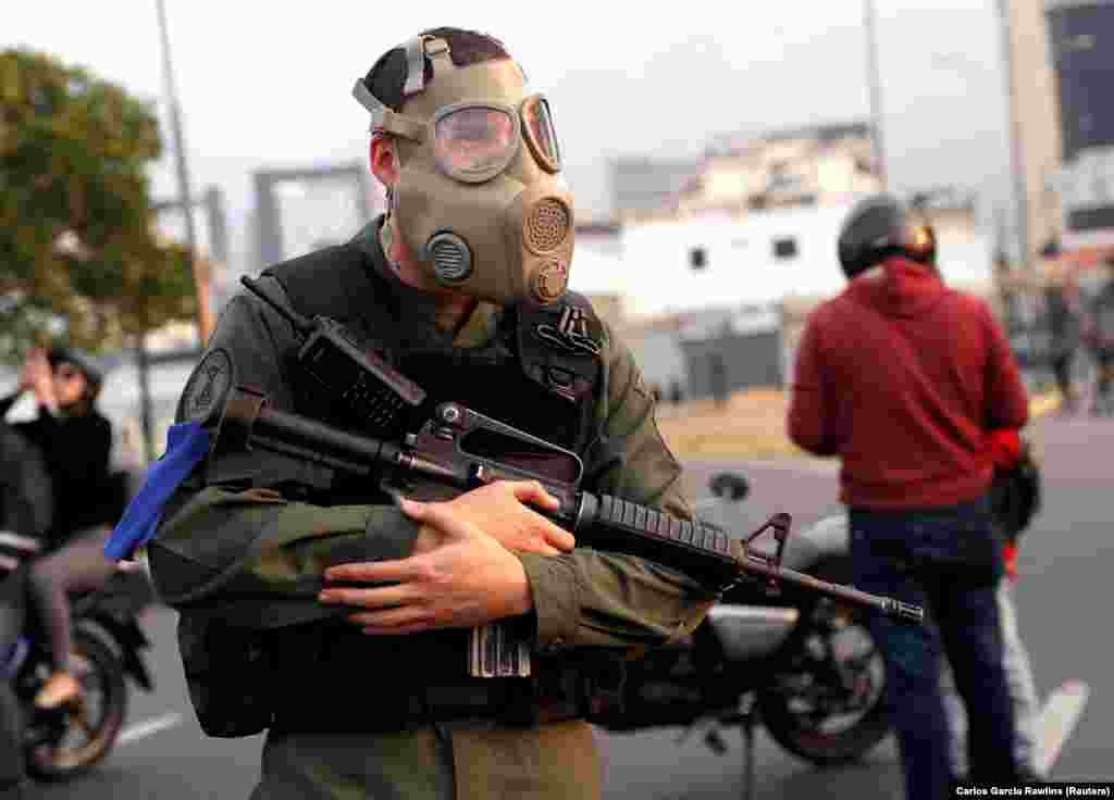 An armed man with a gas mask. According to Reuters, protests are planned for May 1, including what Guaido has said will be &ldquo;the largest march in Venezuela&rsquo;s history,&rdquo; part of what he calls the &ldquo;definitive phase&rdquo; of his effort to take office in order to call fresh elections.