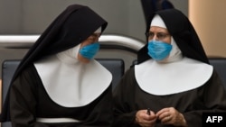 Two nuns wait at Mexico City's international airport wearing surgical masks to ward off the flu.