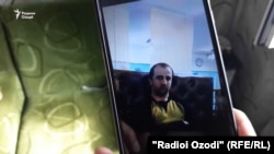 Saodat Solehova holds up a cellphone picture of her son, Nekqadam Solehov, a prison inmate who Tajik authorities said died of food poisoning. 