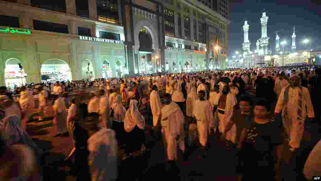 Pilgrims leave the area of the Grand Mosque, seen in the background, following evening prayers during the hajj. (AFP PHOTO/FAYEZ NURELDINE)