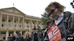 A woman holds a poster with the logo of the Rustavi 2 TV station during a protest rally in front of the Tbilisi city court on October 22.