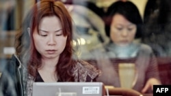 A woman surfs the Internet at a Shanghai cafe.