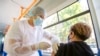 A health worker administers a dose of vaccine against COVID-19 to a woman on a trolleybus used as a mobile vaccination point in Chisinau.