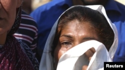 A woman weeps for her missing son at the site of one of the bombings in Lahore.