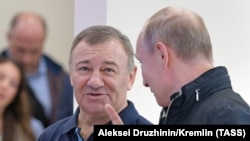 Russian President Vladimir Putin (right) speaks with Arkady Rotenberg as they attend the opening ceremony for a bridge linking the Crimean Peninsula to Russia, in Kerch on May 15.