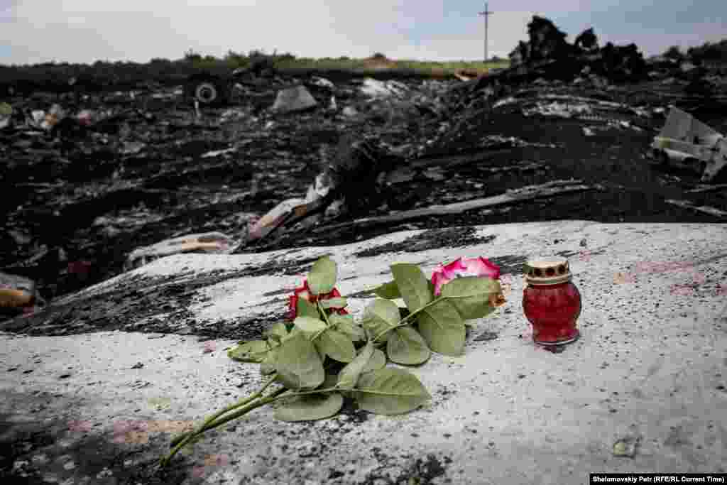 Flowers and candles are placed near wreckage at the crash site of Malaysian Airlines Flight 17 near the village of Grabovo on July 19, 2014, two days after the plane was shot down.