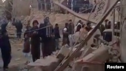 People gather near rubble in the aftermath of Pakistan's military strike on an Iranian village in Sistan-Baluchistan Province on January 18.