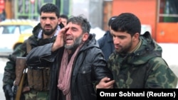 An Afghan man reacts near the site of the suicide attack in Kabul on February 11.