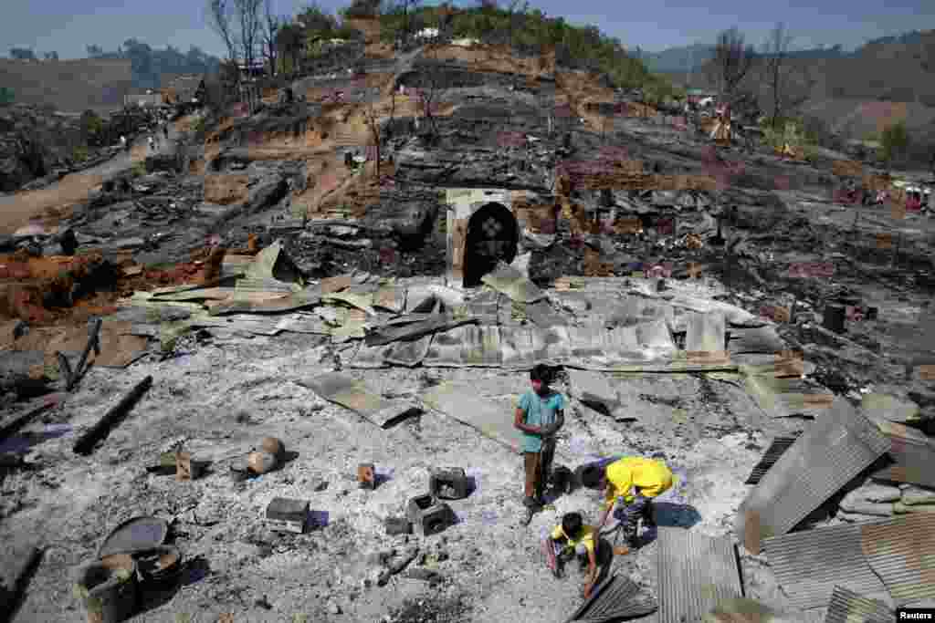 Refugee boys from Myanmar look for items to salvage from the ruins of a burned mosque in the Um-Piam refugee camp after fire engulfed part of it near Mae Sot in February 2012.