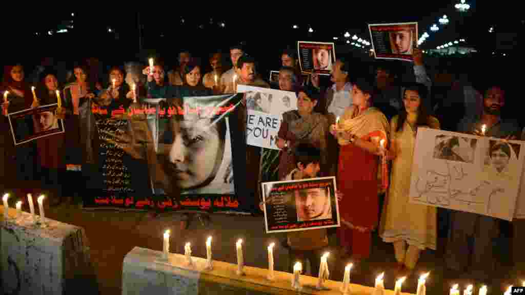 Civil society activists and journalists in Islamabad carry candles during continuing protests against the assassination attempt.