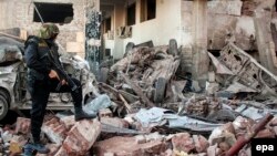 Egyptian security forces inspect the site of a deadly explosion outside police headquarters in Mansoura, Egypt, in December 2013. The Sinai-based militant group Ansar Bayit al-Maqdis had threatened the country's soldiers with death unless they deserted the army.