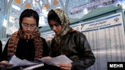 Two Iranian women cast ballots at a polling station in Tehran in Iran's city council elections in 2006.