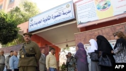 Egyptians queue up outside a school turned into a polling station in Mansura for the March 19 referendum on constitutional changes.