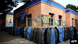 Afghan women queue outside a school to vote in presidential and local elections in the northwestern city of Herat on April 5. Female participation in the polls was far higher than expected.