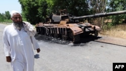 A local man walks past the wreckage of an army tank destroyed by Taliban militants in the troubled Buner district on May 22.